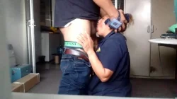 Empleada de limpieza agachada chupando verga en una oficina a un hombre